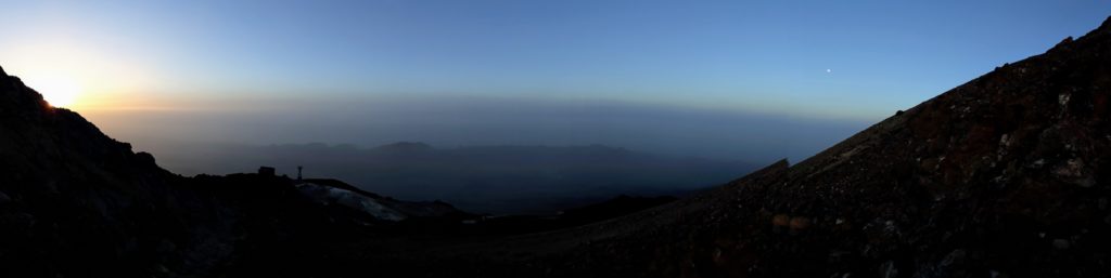 Übergang von Nacht zu Tag: links Sonnenaufgang, rechts der Mond