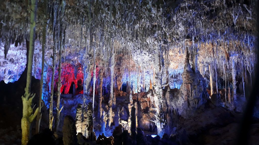 Bunt angestrahlte Stalaktiten und Stalagmiten in der Tropfsteinhöhle Coves dels Hams auf Mallorca