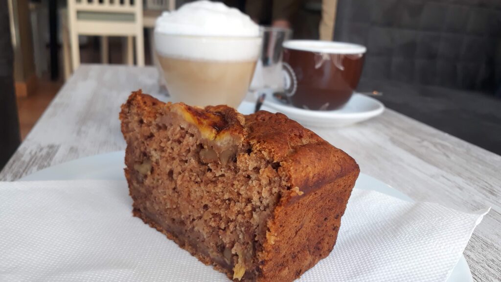 Veganes Bananenbrot und Latte Macchiato in einer Bäckerei auf Mallorca